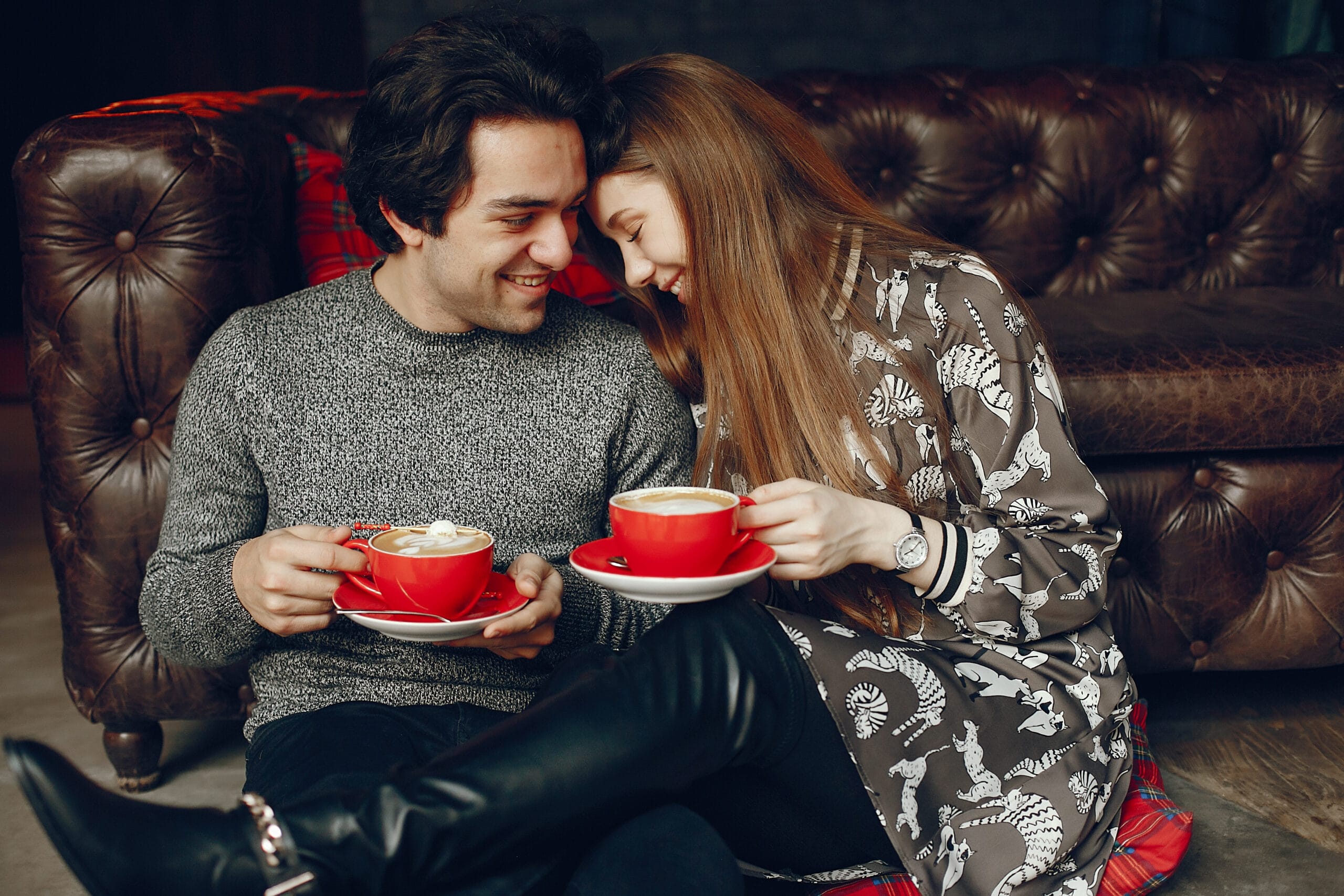 Beautiful couple sitting in a cafe. Cute girl in a shirt. Man in a gray sweater. Couple drinking a coffee