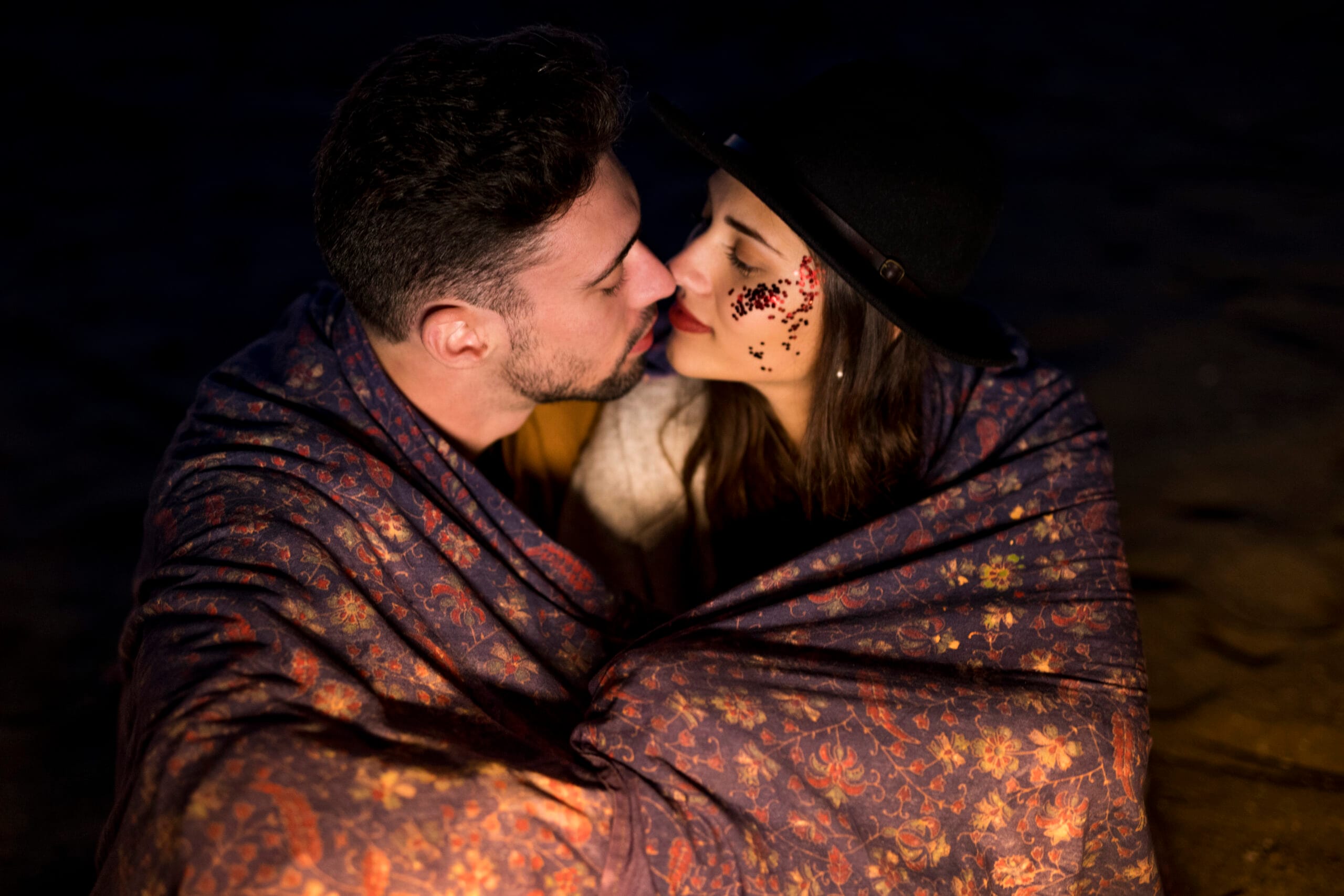 young-couple-blanket-sitting-sandy-sea-shore